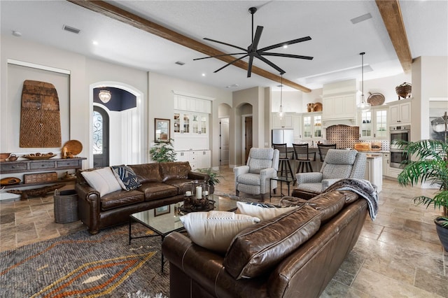 440 Lambert Ave, Flagler Beach, FL 32136 - living room with arched walkways, stone tile floors, ceiling fan, and beam ceiling
