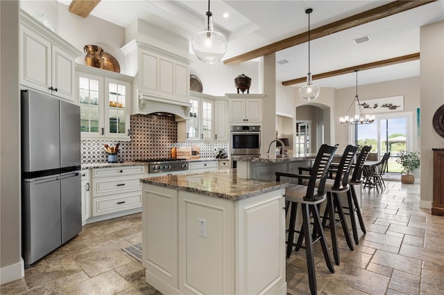 440 Lambert Ave, Flagler Beach, FL 32136 - kitchen with stainless steel appliances, stone tile flooring, tasteful backsplash, a kitchen island with sink, and beamed ceiling