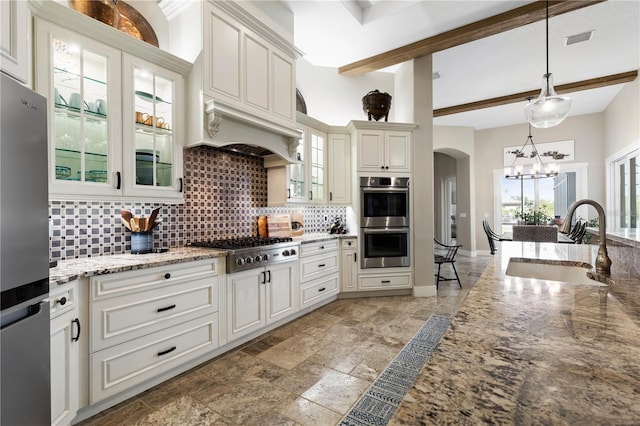 440 Lambert Ave, Flagler Beach, FL 32136 - kitchen featuring a sink, appliances with stainless steel finishes, backsplash, a chandelier, and arched walkways