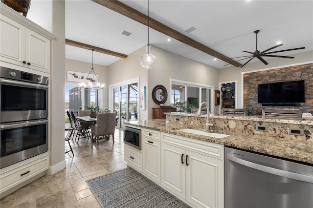 440 Lambert Ave, Flagler Beach, FL 32136 - kitchen with stainless steel appliances, a sink, stone tile floors, beam ceiling, and open floor plan