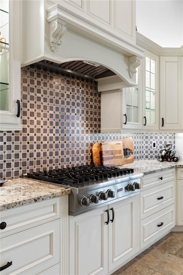 440 Lambert Ave, Flagler Beach, FL 32136 - kitchen with stainless steel gas cooktop, decorative backsplash, glass insert cabinets, and custom range hood
