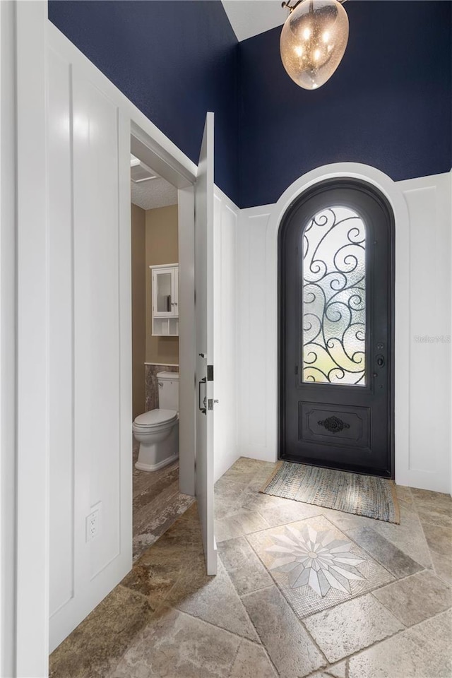 440 Lambert Ave, Flagler Beach, FL 32136 - entrance foyer featuring stone finish flooring, arched walkways, and a towering ceiling