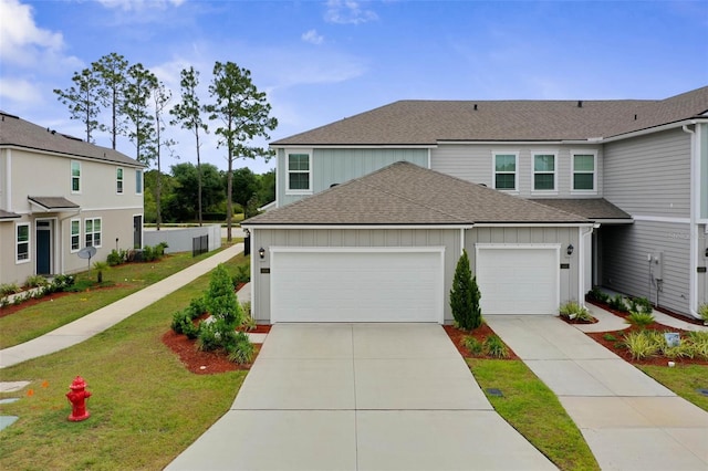 155 Redbud Rd, Palm Coast, FL 32137 - view of front facade featuring a shingled roof, an attached garage, driveway, a front yard, and board and batten siding