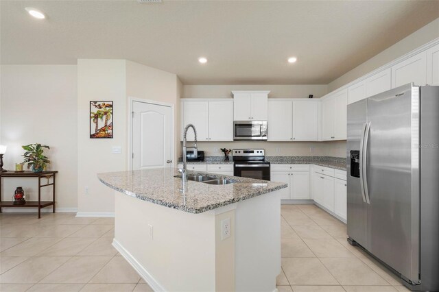 155 Redbud Rd, Palm Coast, FL 32137 - kitchen with stainless steel appliances, light tile patterned floors, a kitchen island with sink, light stone countertops, and recessed lighting