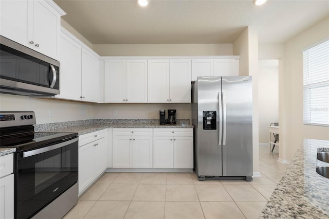 155 Redbud Rd, Palm Coast, FL 32137 - kitchen featuring stainless steel appliances, white cabinetry, light tile patterned floors, light stone counters, and recessed lighting