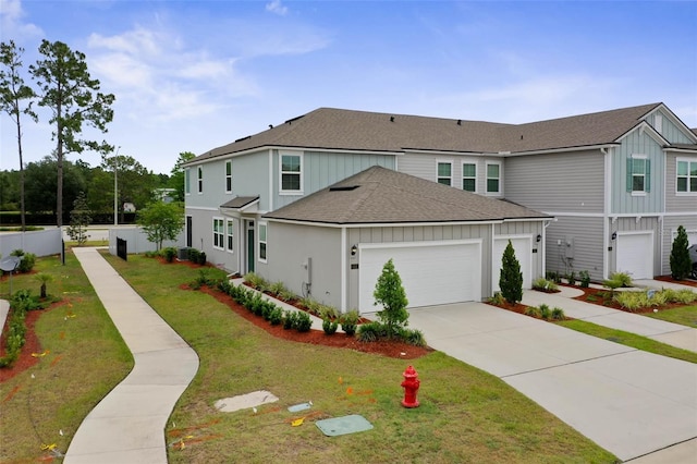 155 Redbud Rd, Palm Coast, FL 32137 - view of front facade with roof with shingles, an attached garage, concrete driveway, a front yard, and board and batten siding