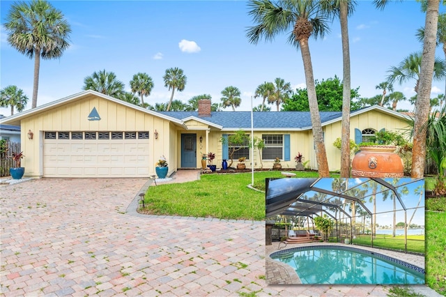 940 Lambert Ave, Flagler Beach, FL 32136 - view of front of property with a chimney, a front yard, a garage, driveway, and glass enclosure