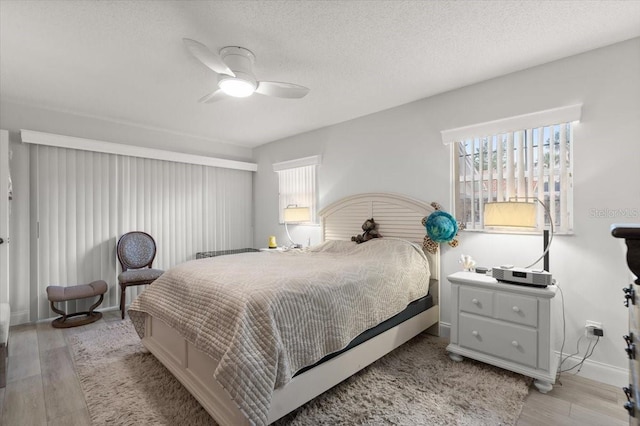940 Lambert Ave, Flagler Beach, FL 32136 - bedroom with light wood finished floors, baseboards, a ceiling fan, and a textured ceiling