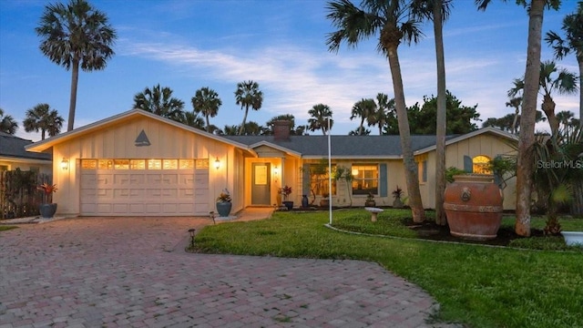 940 Lambert Ave, Flagler Beach, FL 32136 - single story home with an attached garage, a front yard, decorative driveway, and board and batten siding