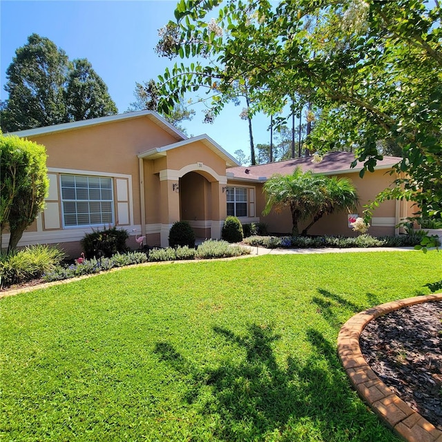 ranch-style house with stucco siding and a front yard