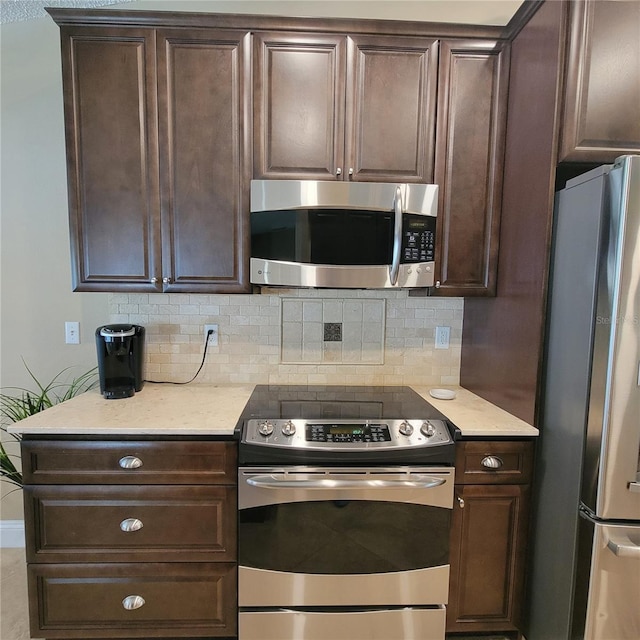 kitchen featuring appliances with stainless steel finishes, dark brown cabinets, and decorative backsplash