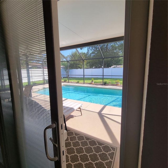 view of pool with fence, a patio area, and a lanai