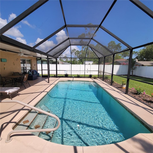 view of pool with a fenced backyard, a patio area, and glass enclosure
