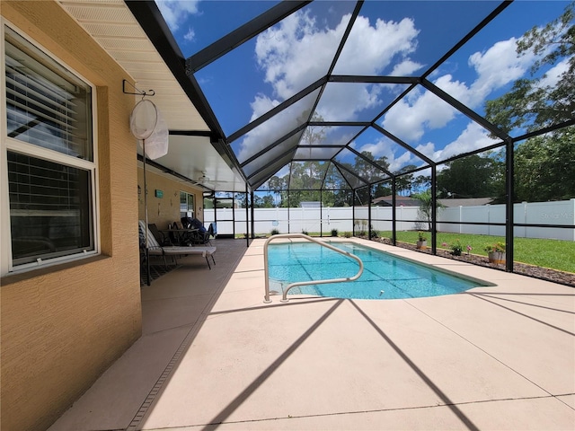view of swimming pool featuring a patio area, a fenced backyard, and glass enclosure