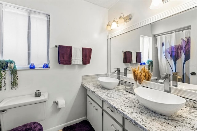 27 Black Hawk Pl, Palm Coast, FL 32137 - full bathroom featuring toilet, double vanity, a shower with curtain, and baseboards