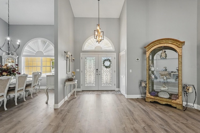 2 Cleveland Ct, Palm Coast, FL 32137 - entryway with a chandelier, high vaulted ceiling, wood finished floors, and french doors