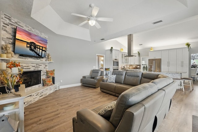 2 Cleveland Ct, Palm Coast, FL 32137 - living room featuring a stone fireplace, ceiling fan, light wood-style flooring, and high vaulted ceiling