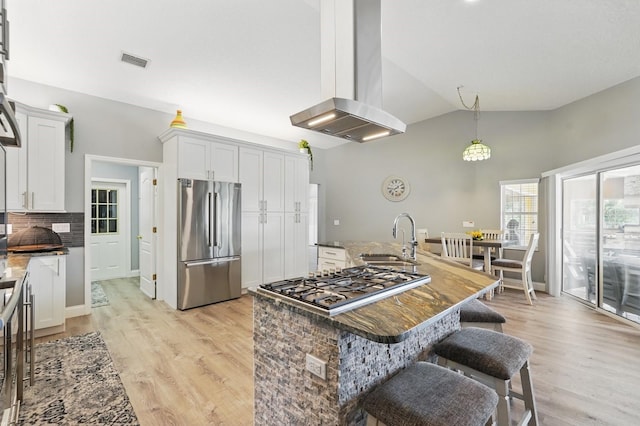 2 Cleveland Ct, Palm Coast, FL 32137 - kitchen with appliances with stainless steel finishes, island exhaust hood, vaulted ceiling, light wood-type flooring, and a breakfast bar