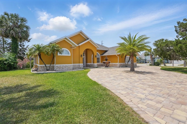 2 Cleveland Ct, Palm Coast, FL 32137 - view of front facade featuring stucco siding, a front lawn, and stone siding