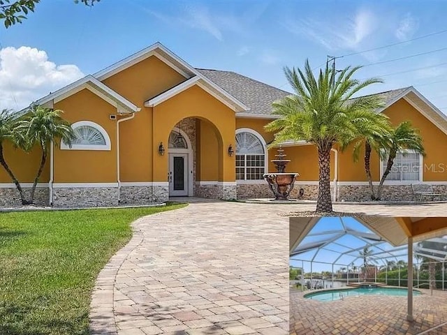 2 Cleveland Ct, Palm Coast, FL 32137 - view of front facade featuring stucco siding, stone siding, an outdoor pool, a front yard, and a lanai