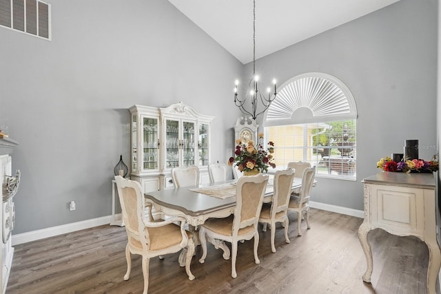 2 Cleveland Ct, Palm Coast, FL 32137 - dining area with high vaulted ceiling, a chandelier, and light wood-style flooring
