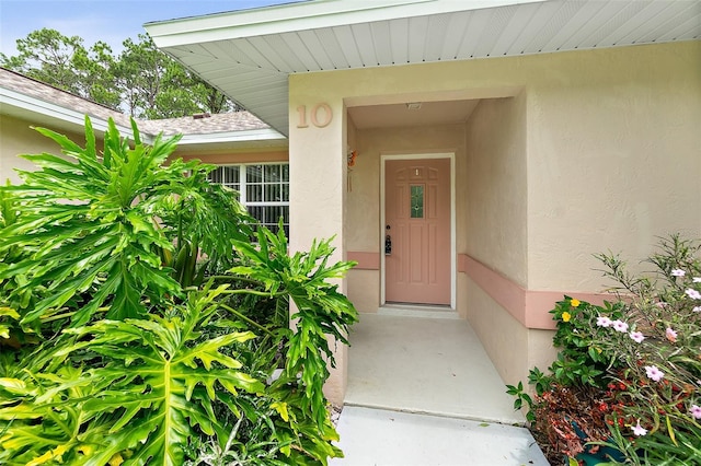 10 Eastwood Dr, Palm Coast, FL 32164 - entrance to property featuring stucco siding and roof with shingles