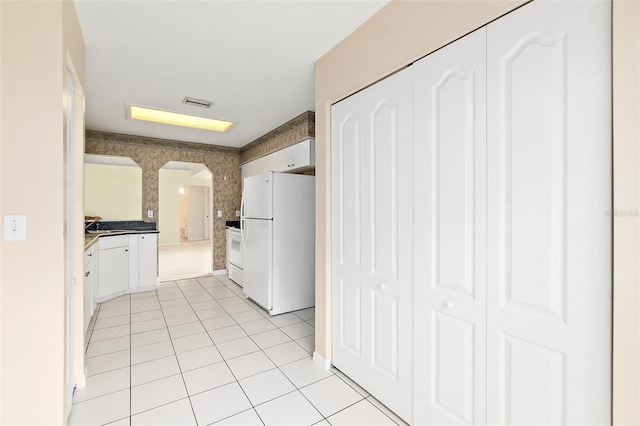 10 Eastwood Dr, Palm Coast, FL 32164 - hallway featuring arched walkways, light tile patterned floors, wallpapered walls, and a sink