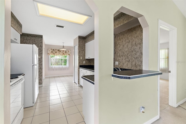 10 Eastwood Dr, Palm Coast, FL 32164 - kitchen featuring white appliances, white cabinetry, dark countertops, backsplash, and baseboards