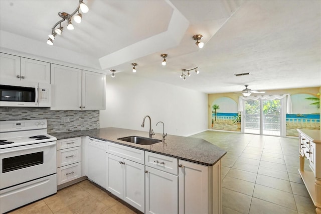 120 Oak Ln, Flagler Beach, FL 32136 - kitchen with white appliances, a sink, rail lighting, and a peninsula