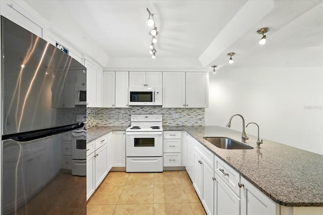 120 Oak Ln, Flagler Beach, FL 32136 - kitchen with white appliances, a sink, a peninsula, backsplash, and light tile patterned floors