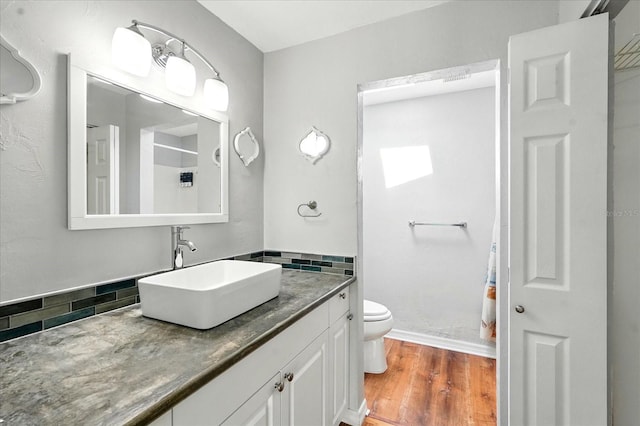 120 Oak Ln, Flagler Beach, FL 32136 - full bath featuring toilet, vanity, backsplash, wood finished floors, and curtained shower