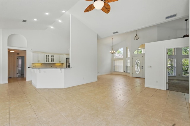 47 Old Oak Dr S, Palm Coast, FL 32137 - unfurnished living room featuring high vaulted ceiling, ceiling fan, light tile patterned floors, a chandelier, and recessed lighting