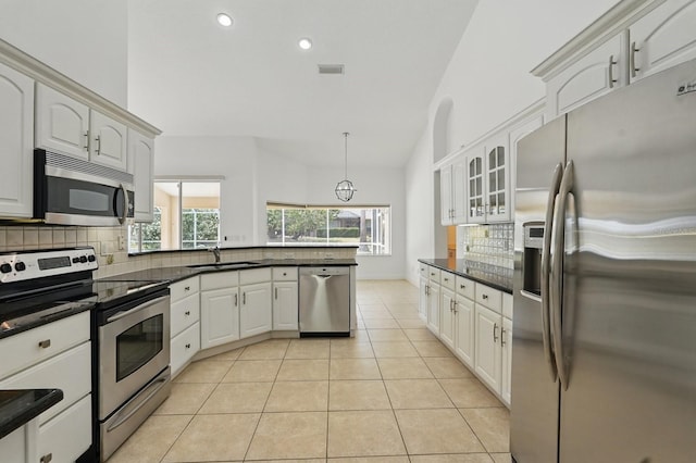 47 Old Oak Dr S, Palm Coast, FL 32137 - kitchen with appliances with stainless steel finishes, decorative backsplash, a peninsula, a sink, and light tile patterned floors