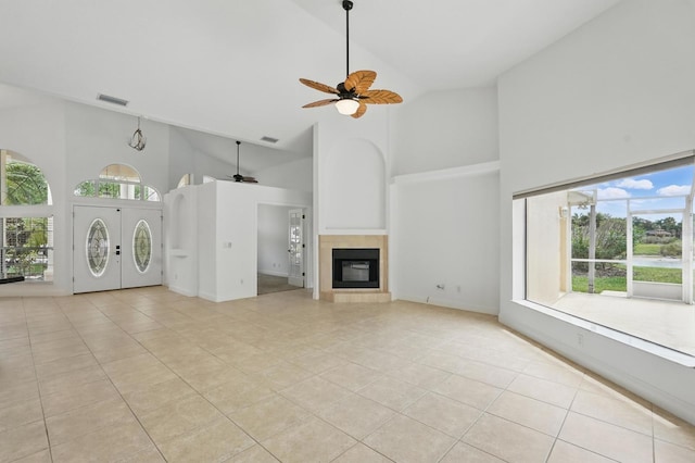 47 Old Oak Dr S, Palm Coast, FL 32137 - unfurnished living room with high vaulted ceiling, ceiling fan, light tile patterned flooring, plenty of natural light, and a tile fireplace