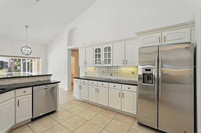 47 Old Oak Dr S, Palm Coast, FL 32137 - kitchen with appliances with stainless steel finishes, dark countertops, backsplash, light tile patterned flooring, and a chandelier
