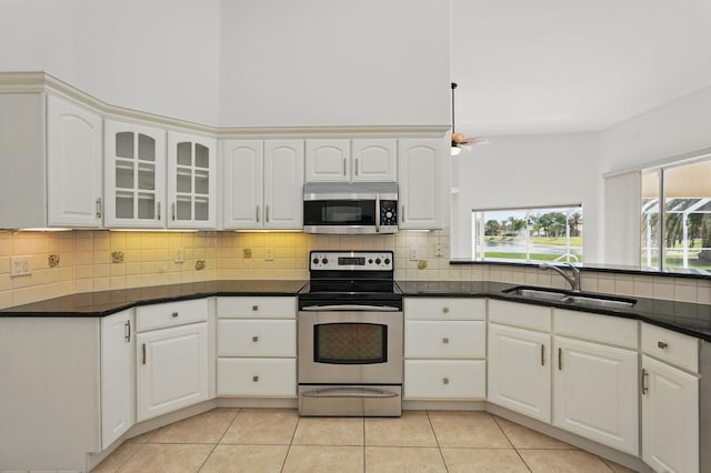 47 Old Oak Dr S, Palm Coast, FL 32137 - kitchen with appliances with stainless steel finishes, a sink, light tile patterned flooring, and decorative backsplash