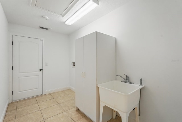 47 Old Oak Dr S, Palm Coast, FL 32137 - laundry room with attic access, a sink, light tile patterned floors, and baseboards