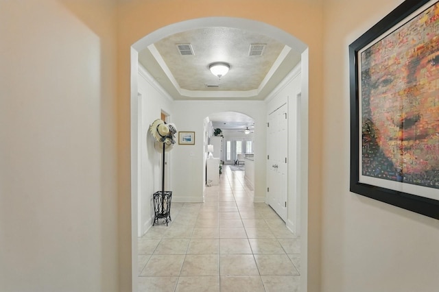 200 Bella Harbor Ct Unit 105, Palm Coast, FL 32137 - hallway featuring arched walkways, light tile patterned floors, a raised ceiling, and baseboards