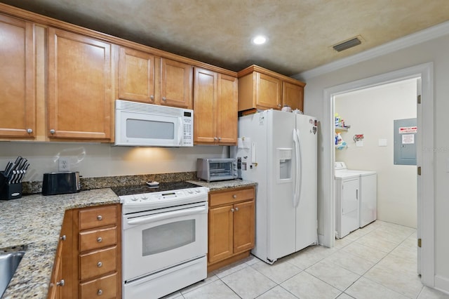 200 Bella Harbor Ct Unit 105, Palm Coast, FL 32137 - kitchen featuring white appliances, washing machine and dryer, brown cabinets, light tile patterned flooring, and light stone countertops