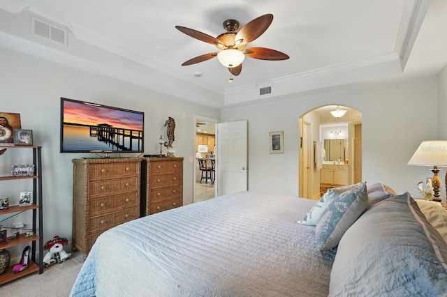 200 Bella Harbor Ct Unit 105, Palm Coast, FL 32137 - carpeted bedroom with a tray ceiling, arched walkways, ornamental molding, ensuite bath, and a ceiling fan