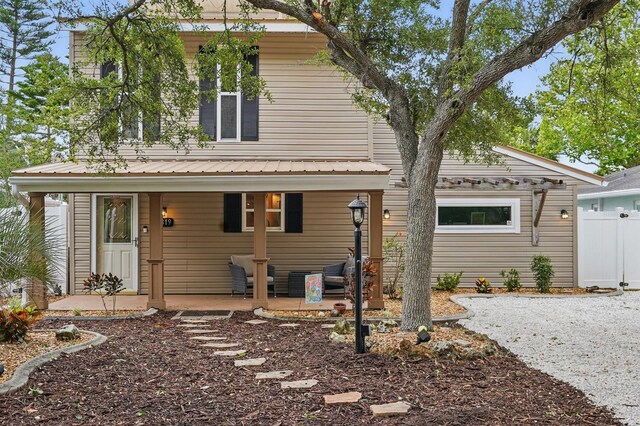 1819 S Flagler Ave, Flagler Beach, FL 32136 - back of house featuring covered porch, metal roof, and fence