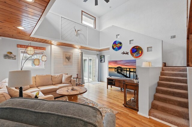 1819 S Flagler Ave, Flagler Beach, FL 32136 - living area with healthy amount of natural light, a towering ceiling, wood finished floors, a ceiling fan, and stairs