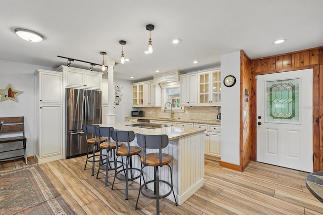1819 S Flagler Ave, Flagler Beach, FL 32136 - kitchen featuring freestanding refrigerator, a sink, light wood finished floors, a kitchen breakfast bar, and recessed lighting