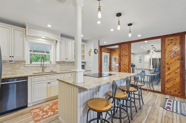 1819 S Flagler Ave, Flagler Beach, FL 32136 - kitchen with dishwasher, a sink, black electric cooktop, decorative columns, and a kitchen island