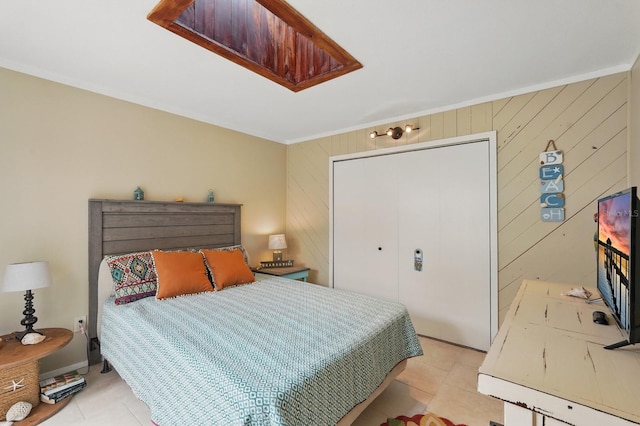 1819 S Flagler Ave, Flagler Beach, FL 32136 - bedroom featuring light tile patterned flooring, crown molding, wooden walls, and a closet