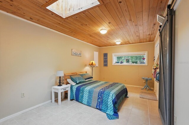 1819 S Flagler Ave, Flagler Beach, FL 32136 - bedroom featuring wood ceiling, light tile patterned floors, a barn door, baseboards, and a skylight