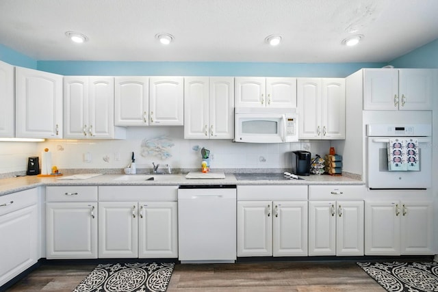 7029 N Ocean Shore Blvd, Palm Coast, FL 32137 - kitchen featuring white appliances, white cabinetry, dark wood-type flooring, a sink, and recessed lighting