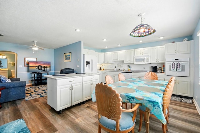 7029 N Ocean Shore Blvd, Palm Coast, FL 32137 - kitchen with white appliances, wood finished floors, ceiling fan, white cabinets, and recessed lighting