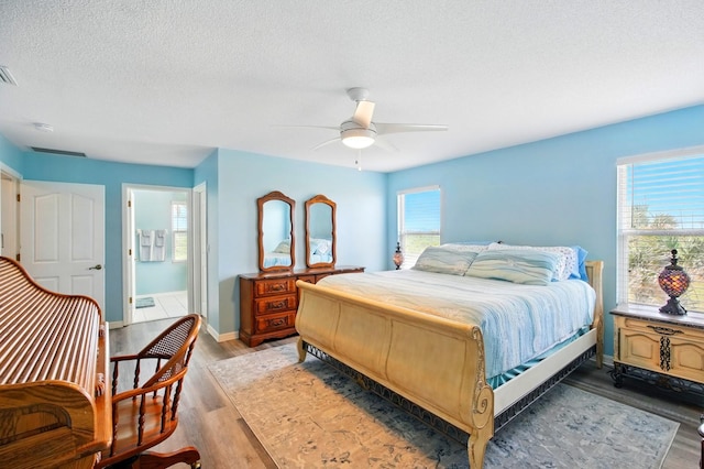 7029 N Ocean Shore Blvd, Palm Coast, FL 32137 - bedroom with light wood-style flooring, baseboards, a textured ceiling, and ceiling fan