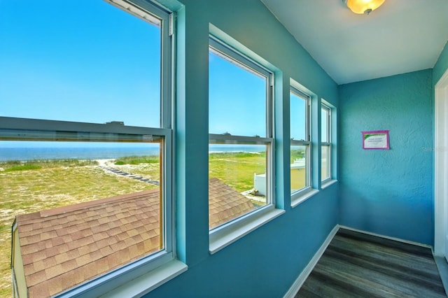 7029 N Ocean Shore Blvd, Palm Coast, FL 32137 - doorway to outside featuring wood finished floors, a water view, and baseboards